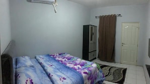 A bedroom with a bed, a wardrobe, a door, and an air conditioning unit. - Hotel O Fgh Residence 1 (Bekasi)
