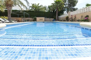 A swimming pool with blue mosaic tiles, surrounded by palm trees and a white fence. - Frederic in Balc n del Mar (Javea)