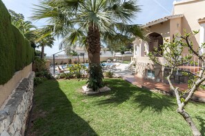 A courtyard with a palm tree, a swimming pool, and a building with a tiled roof. - Frederic in Balc n del Mar (Javea)
