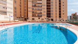 A swimming pool with a clear blue water surface, surrounded by a red and white tiled deck. - Infante in Grau i Platja (Gandia)