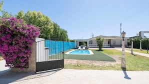 A gated area with a swimming pool, a covered patio, and a building in the background. - Fuentes Del Colorao in Barrio Nuevo (Conil de la Frontera)
