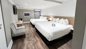 Een hotelkamer met twee bedden, een bureau, een stoel en een televisie.