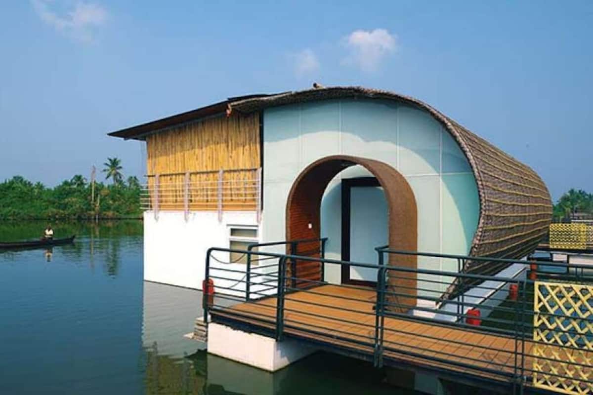 A floating house with a wooden deck and a large archway.