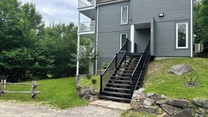 A two-story building with a staircase leading to a balcony. - Swimming Pool & Spa | Condo Mont Tremblant 2 (Mont-Tremblant)