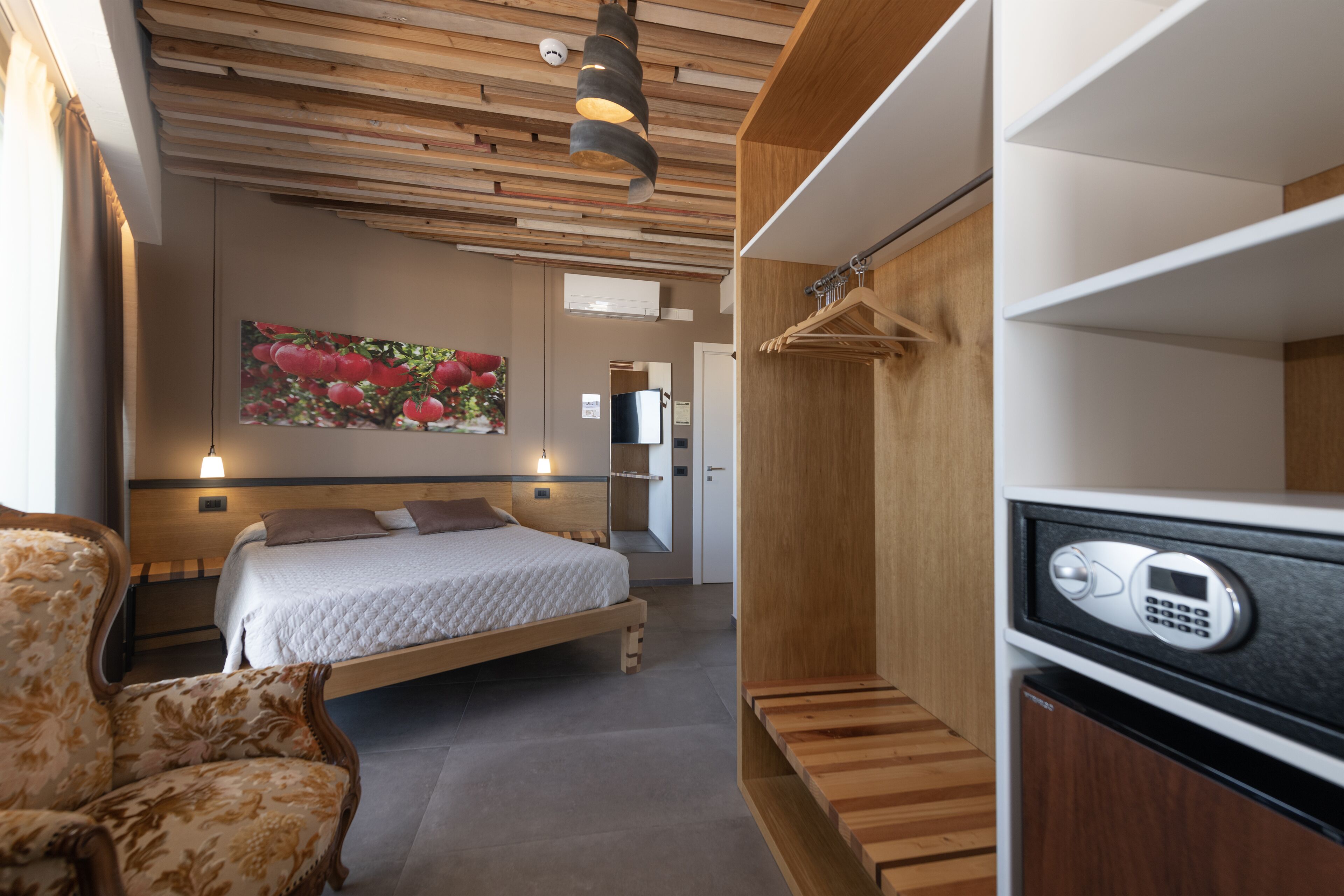 Un dormitorio moderno con una cama, una silla, un armario de madera y un cuadro en la pared.
