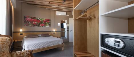 Un dormitorio moderno con una cama, una silla, un armario de madera y un cuadro en la pared.