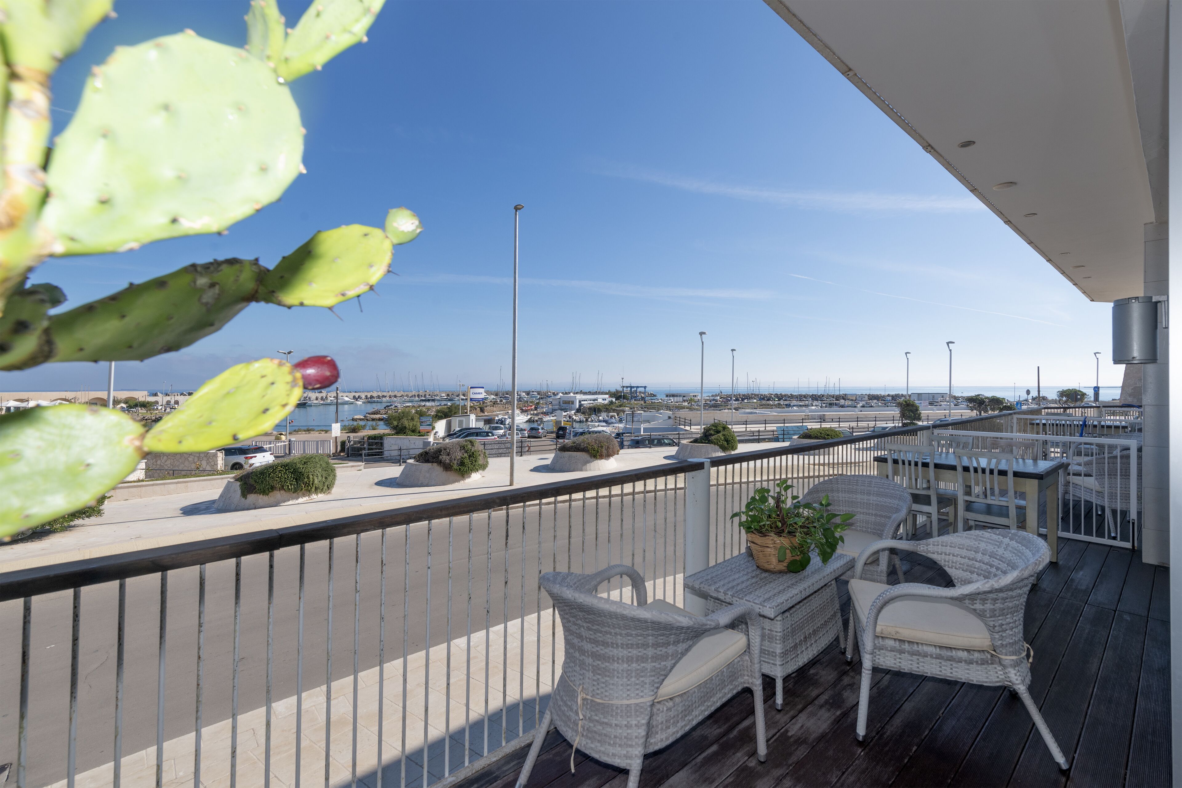 A balcony with wicker furniture and a view of the cityscape.