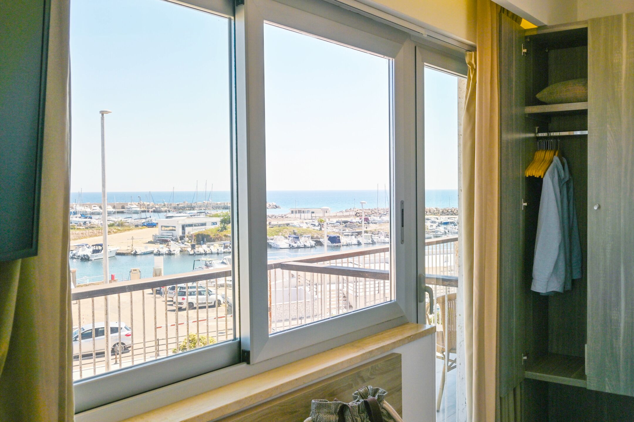 A room with a large window overlooking a marina and boats.