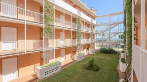 A multi-story hotel with balconies, a central courtyard, and a clear sky. - Las Americas in Islantilla (Isla Cristina)