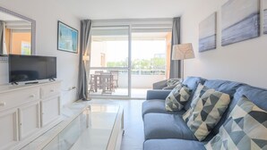 A modern living room with a sofa, TV, and a glass coffee table. - Las Americas in Islantilla (Isla Cristina)