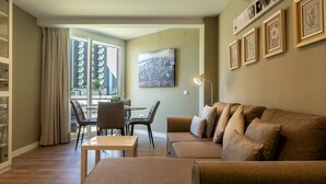 A modern living room with a sofa, ottoman, and dining table. - La Playa in Torremolinos (Torremolinos)