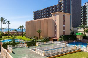Un hotel con area piscina, diversi balconi e vista sul mare.