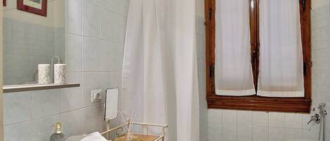 Un baño con lavamanos, inodoro y zona de ducha.