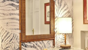 A room with a large mirror, a lamp, a desk, and a chair. - MADAMA GUEST HOUSE (Florence)