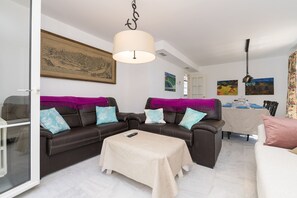 Relax in this stylish living room with a comfortable sofa, dining area, and large artwork.