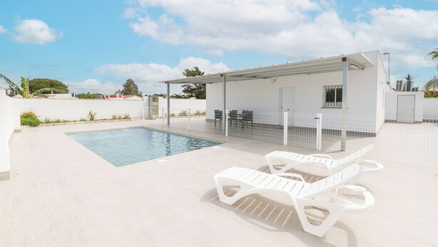 A swimming pool area with a covered seating area and lounge chairs. - Miamar 1 in Hozanejos (Chiclana de la Frontera)