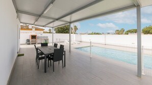A covered patio with a pool, dining table, and chairs. - Miamar 1 in Hozanejos (Chiclana de la Frontera)