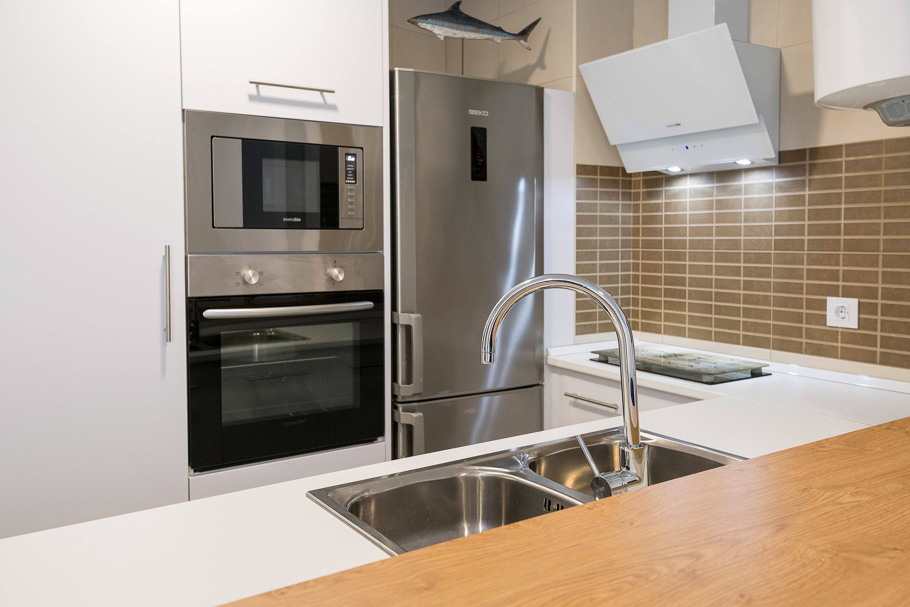 A modern kitchen with stainless steel appliances, a microwave, oven, and refrigerator.