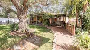A patio area with a stone pathway, a swing set, and a pergola structure.