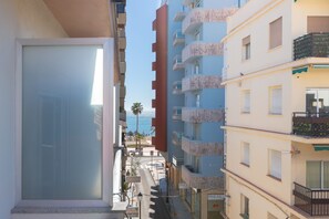 A narrow street with multi-story buildings, balconies, and a clear view of the sea. - Montealba in Costa del Sol (Fuengirola)