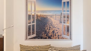 A wall with a large window depicting a beach scene. - Marina De La Duquesa 805 (Manilva)