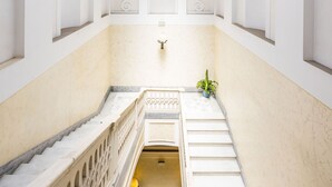 A spacious interior with a high ceiling and skylight, marble steps, and a central staircase. - Blu Breeze on Seafront (Naples)