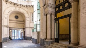 A spacious interior with high ceilings, arched doorways, and a central open area. - Blu Breeze on Seafront (Naples)