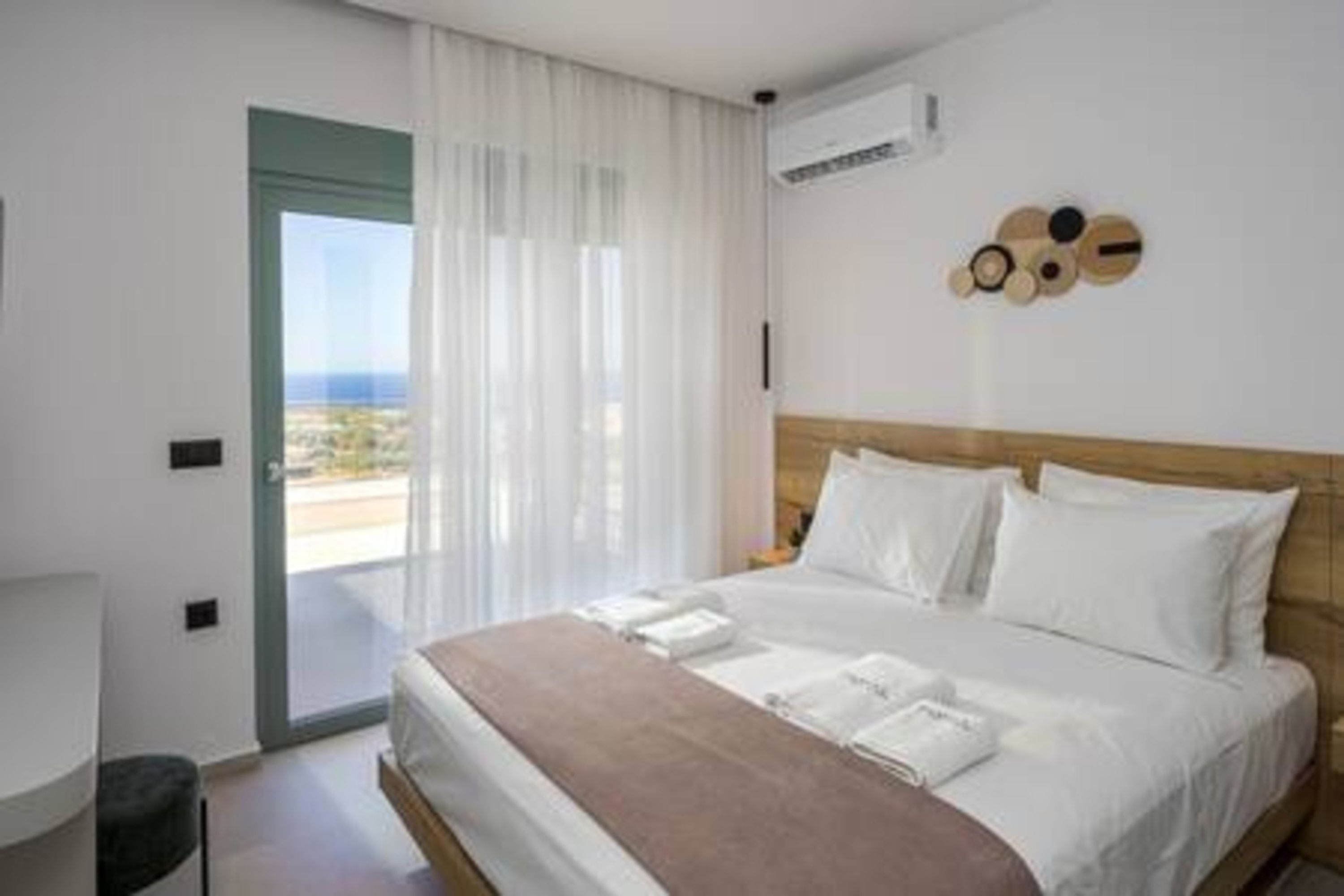 Een hotelkamer met een bed, uitzicht door een deur en een wanddecoratie.