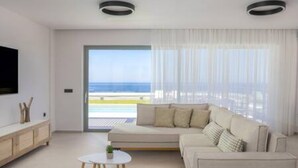 Un soggiorno moderno con un divano, un tavolino e una TV montata a parete.