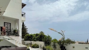 Eine Dachterrasse mit Pool, Gartenmöbeln und Blick auf die Skyline der Stadt.