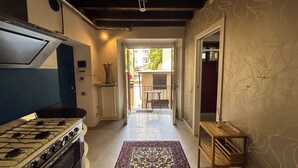 A kitchen with a gas stove, a blue cabinet, and a patterned rug leading to a balcony. - [Historic House] in the Heart of Bergamo (Bergamo)
