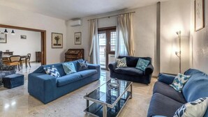 A living room with two sofas, a glass coffee table, and a dining area with a piano. - Spacious Apartment Near Saint Peter's Basilica
 (Roma)