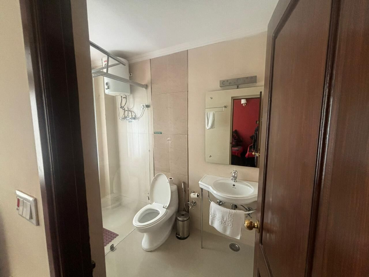 Une salle de bain avec des toilettes, un lavabo et un miroir.