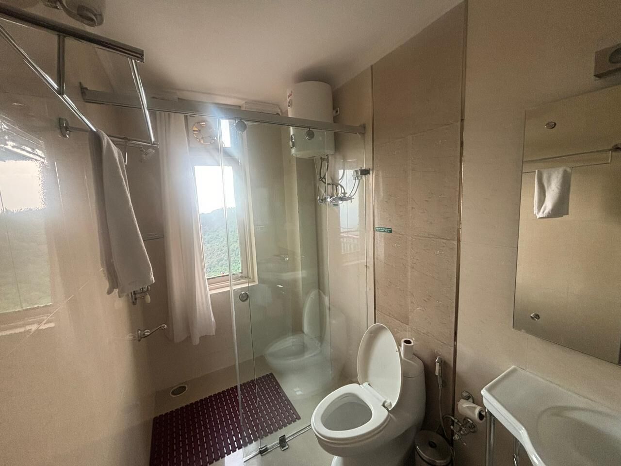 Une salle de bain compacte avec une douche à parois de verre, des toilettes et un lavabo.