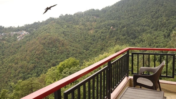 Un balcone con vista su una montagna boscosa.