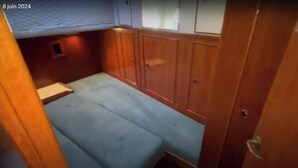 A compact cabin with a bunk bed, wooden paneling, and a small window. - Boat rental (Marseille)