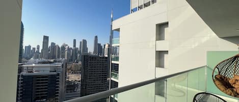 A high-rise building with a view of a city skyline, including a prominent skyscraper.