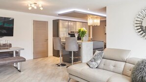 A modern living room with a sofa, a coffee table, and a dining area with chairs and a table. - Host Stay Casa Feliz (Hull)