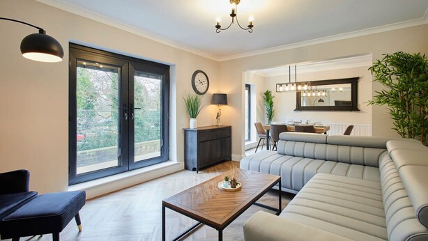 A modern living room with a sofa, a coffee table, and a dining area. - Host Stay Roseberry Topping Townhouse (Middlesbrough)