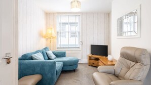 A room with a sofa, a chair, a TV, and a lamp. - Host Stay Abbey View (Whitby)