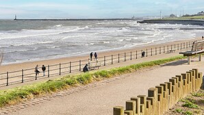 A coastal walkway with a railing, benches, and a view of the sea. - Host Stay Emilyn House (Sunderland)