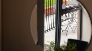 A circular mirror reflecting a patio area with a table and chairs, a brick wall, and a green fence. - Host Stay Richmond Place 003 (Liverpool)