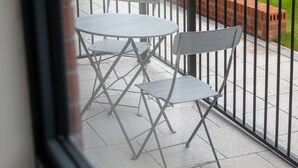 A balcony with a metal railing, a small table, and two chairs. - Host Stay Richmond Place 003 (Liverpool)