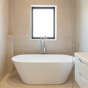 A modern bathroom with a freestanding bathtub, a window above the sink, and a glass shower enclosure. - Host Stay The Pilgrim House (Liverpool)
