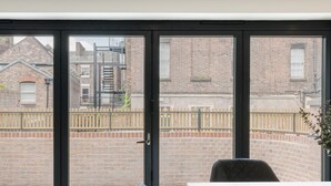A modern room with a large sliding glass door leading to a backyard.