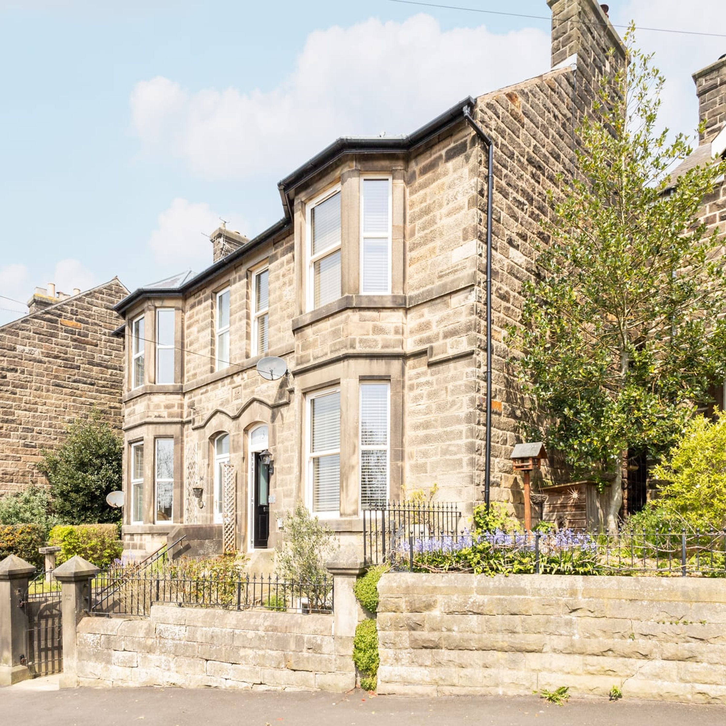 A stone building with a symmetrical facade, multiple windows, and a gated entrance.