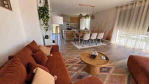 A modern living room with a brown sofa set, a wooden coffee table, and a dining area with a wooden table and chairs. - La Villa Pangea, Havre de Paix Avec vue sur la Rivière et la Nature (Gignac)