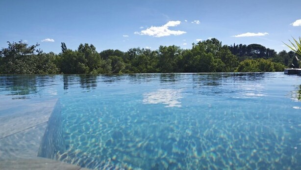 A clear blue infinity pool with a view of dense greenery and trees in the background. - La Villa Pangea, Havre de Paix Avec vue sur la Rivière et la Nature (Gignac)