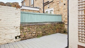 A stone building with a wooden deck and a green fence. - Host Stay Wild Springs (Wetherby)