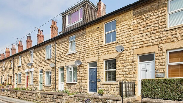 A row of terraced houses with stone walls, multiple chimneys, and satellite dishes. - Host Stay Wild Springs (Wetherby)